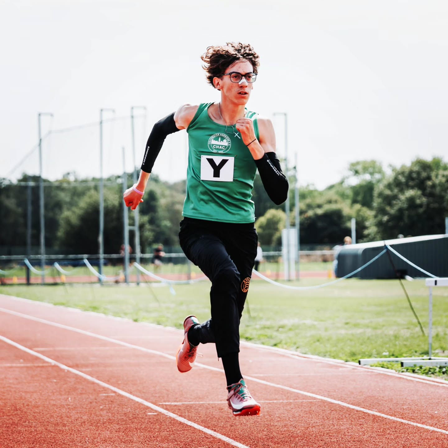 Bronson Hearn-Smith berlari di lintasan 200 meter, mengenakan seragam Inggris, dengan papan waktu menunjukkan 20,70 deti